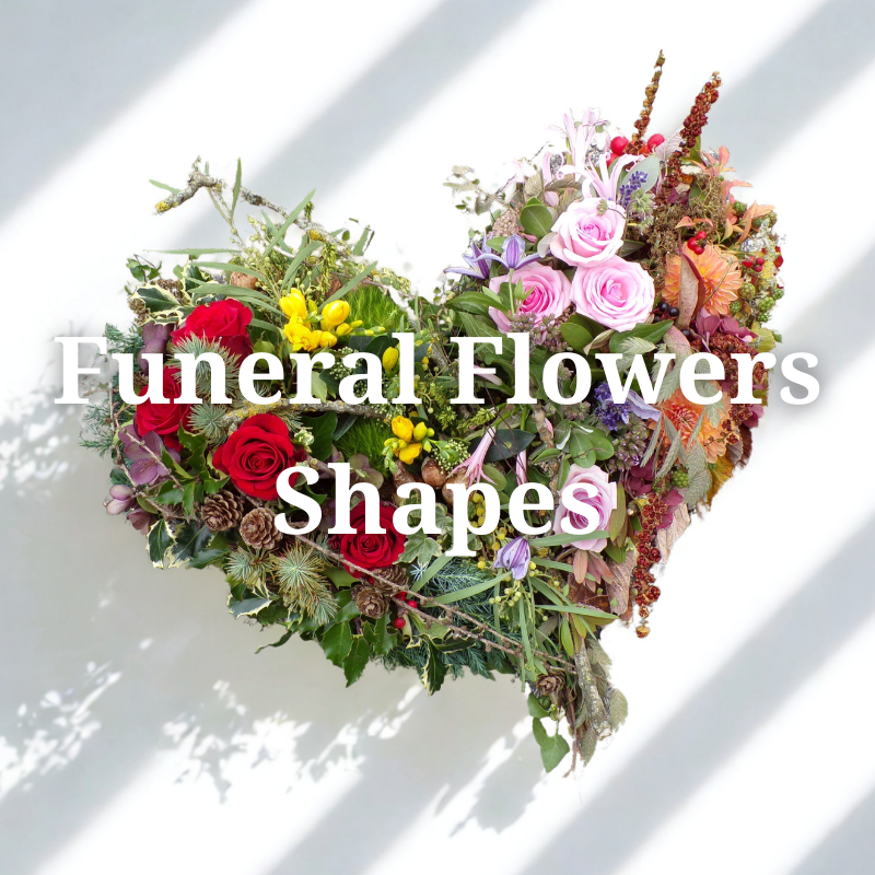 Heart-shaped funeral flowers with red roses, pink and purple flowers